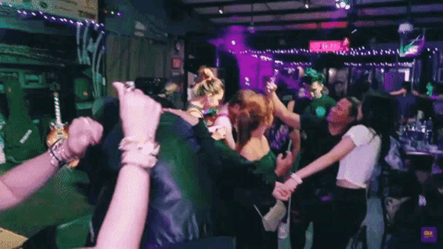 a group of people are dancing in a room with a sign that says ' a & a ' on it