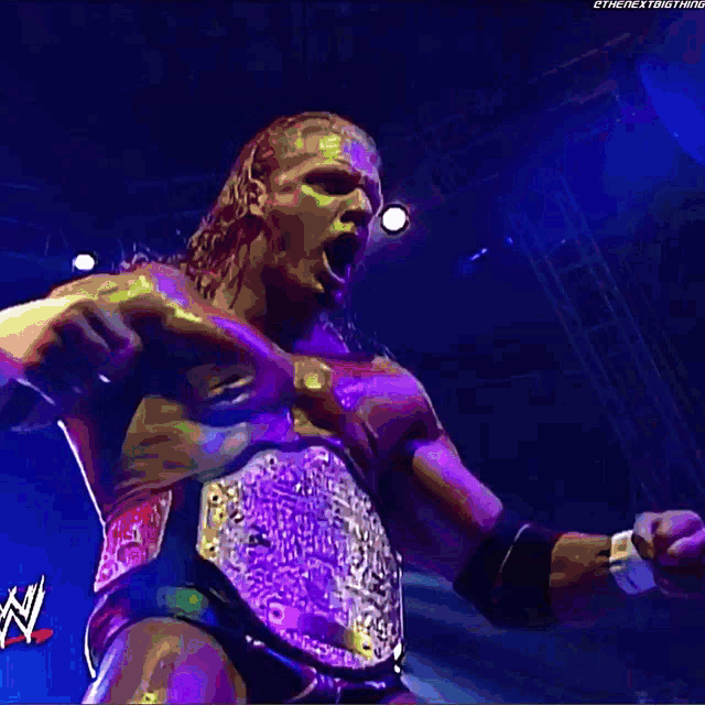 a man wearing a wrestling belt with the letters w on it