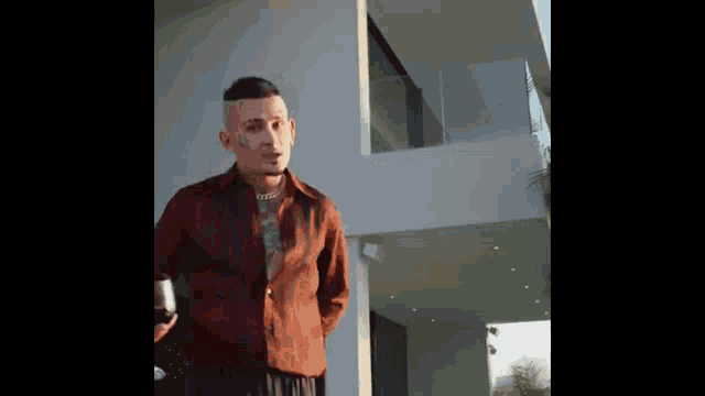 a man with a tattoo on his face is holding a glass of wine in front of a large white building .