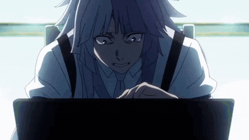 a person is sitting in front of a laptop computer with a serious look on their face .