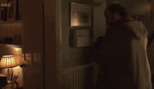 a person is standing in a doorway with a bbc logo on the bottom right