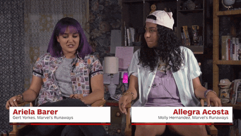 ariela barer and allegra acosta sit next to each other in a room