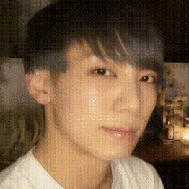 a close up of a person 's face with a white shirt on .