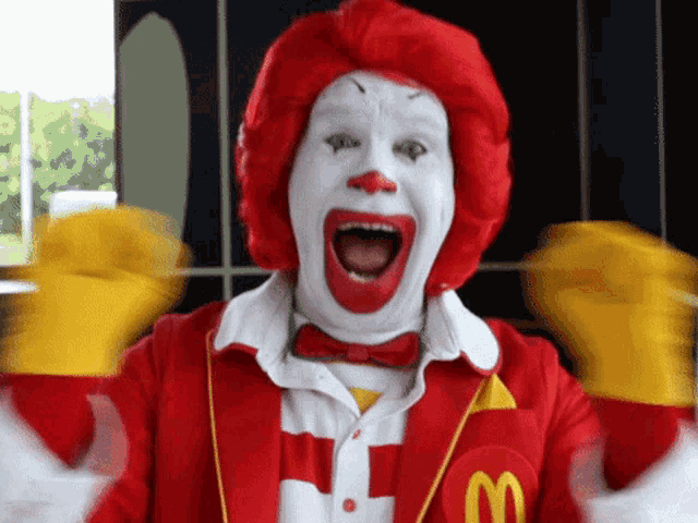 a mcdonald 's clown with red hair and a m on his jacket