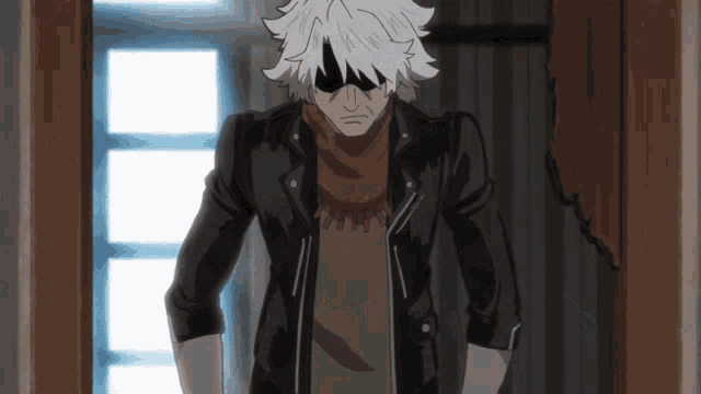 a man wearing sunglasses and a black jacket stands in a hallway