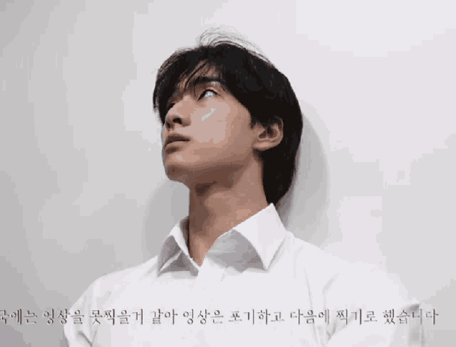a man wearing a white shirt is looking up at something