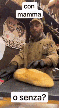 a man is cutting a loaf of bread in front of a sign that says " con mamma o senza "