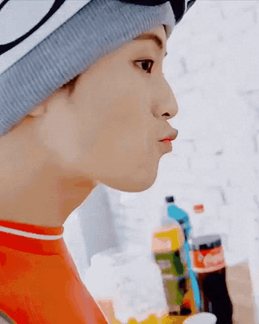 a close up of a person 's face with a bottle of coke in the background