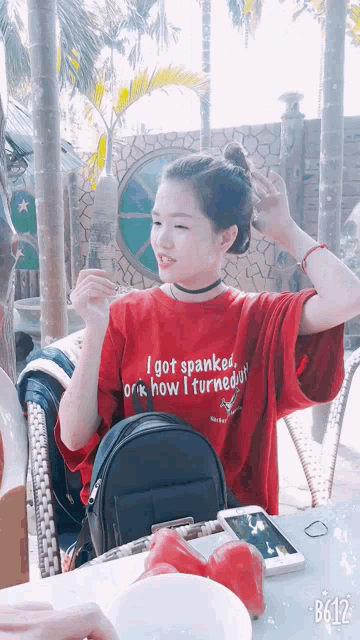 a girl wearing a red shirt that says i got spanked