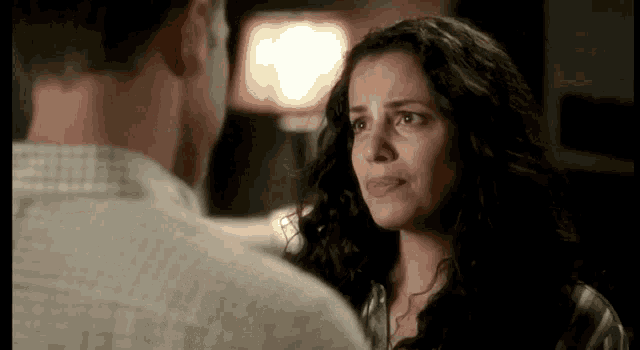 a man and a woman are looking at each other in a dark room .
