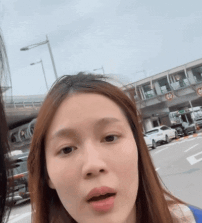 a woman stands in front of a sign that says e