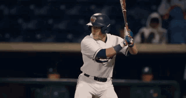 a baseball player is swinging a bat and wearing a helmet with the letter t on it