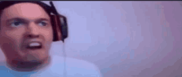 a man wearing headphones is making a funny face while looking up .