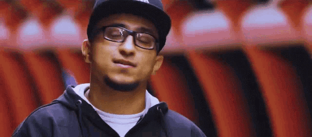a man wearing glasses and a hat with the word adidas on the front