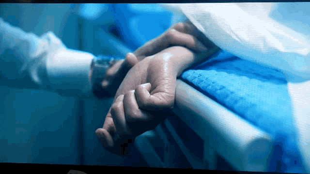 a person holding another person 's hand in a dark room