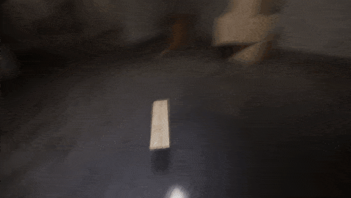 a dark room with a wooden table and a light on the floor