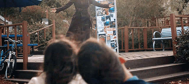 a woman is standing on a stage with her arms outstretched in front of a group of people .