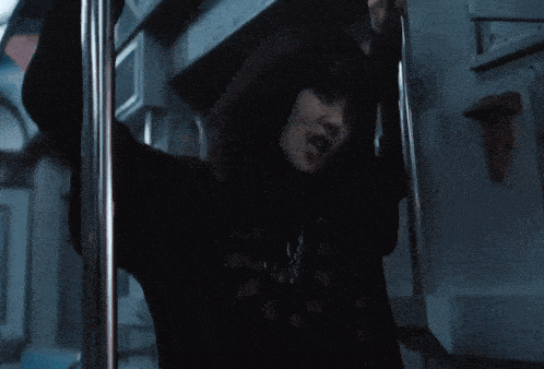 a blurry picture of a person in a dark room reaching for something