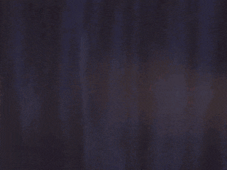 a purple light beam is shining on a dark background .