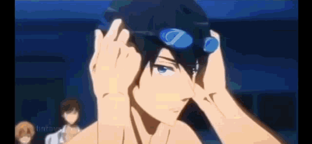 a man wearing swimming goggles is getting ready to swim .