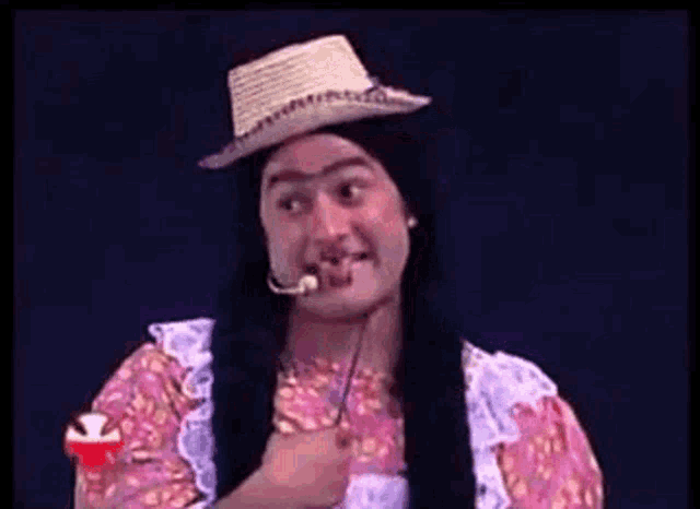 a man with long hair wearing a straw hat and a microphone .