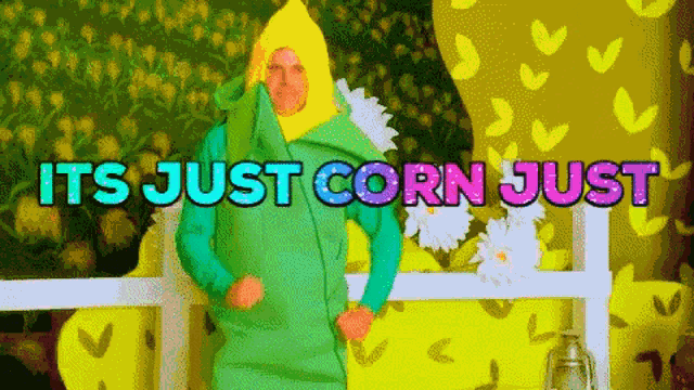 a man in a corn costume is dancing in front of a sign that says its just corn just