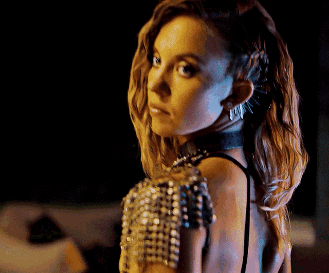 a woman with spikes in her hair is wearing a black dress