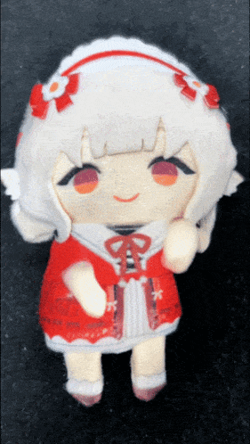 a stuffed doll with white hair and red eyes is wearing a red and white dress