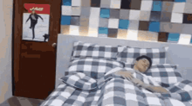a man is sleeping on a bed in a room with a poster on the wall that says ' ace '