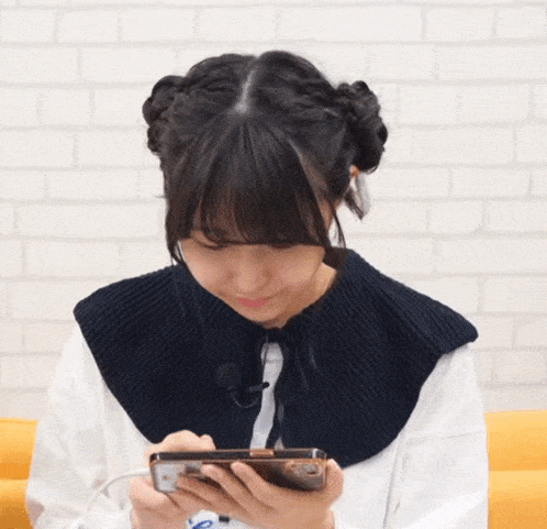 a girl wearing headphones and a black collar is looking at her phone