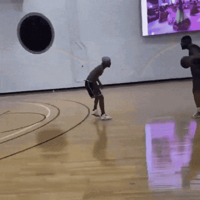 a person playing basketball on a court with a black circle in the background