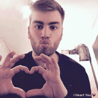 a man making a heart shape with his hands with the words i heart you below him