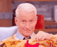 a man is holding a pile of french fries in his hands .