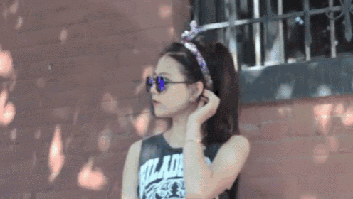 a woman wearing sunglasses and a headband that says ' wizard ' on it