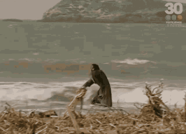 a man is crawling out of the ocean .