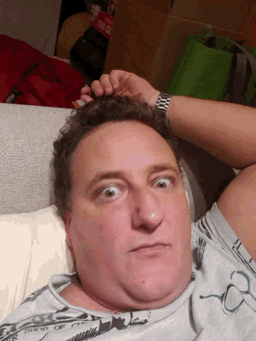 a man laying on a couch with a watch on his wrist that says ' rolex ' on it