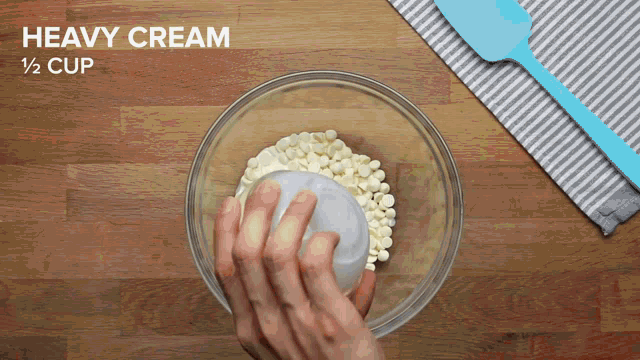 heavy cream is being poured into a glass bowl
