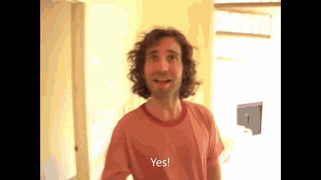 a man in a red shirt says yes in a video