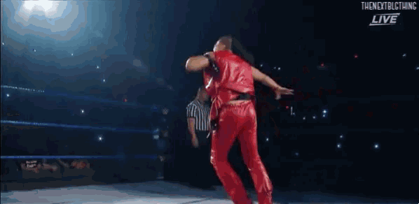 a wrestler in a red robe is kicking his leg in the air .