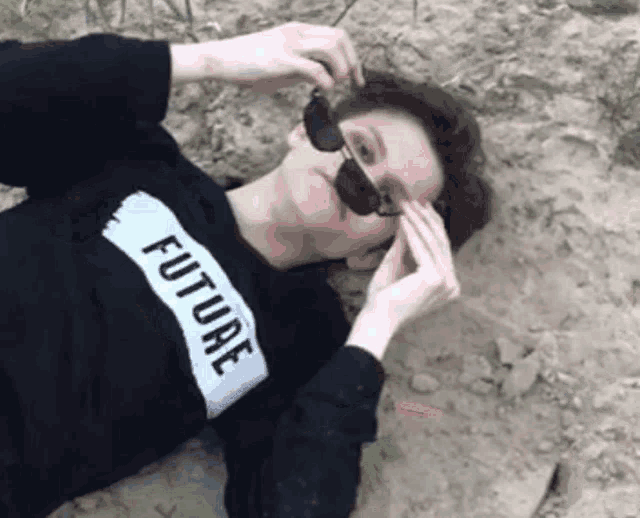 a person wearing sunglasses and a black sweater that says future