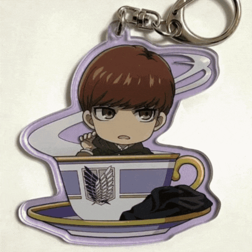 a keychain of a boy in a cup with wings on it