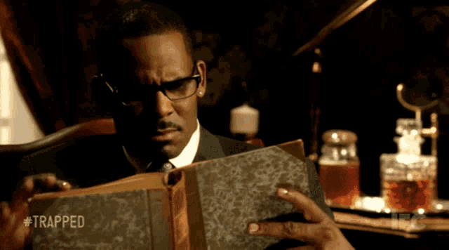 a man is reading a book with the hashtag #trapped on the bottom
