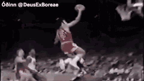 a man is jumping in the air with a basketball while playing basketball .