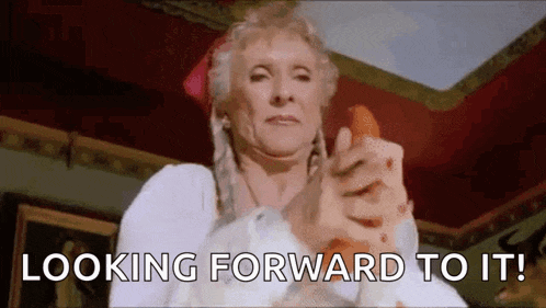 an elderly woman is holding a carrot in her hand and pointing at it .
