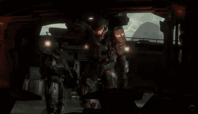 a man in a red helmet is standing next to another man in a black helmet