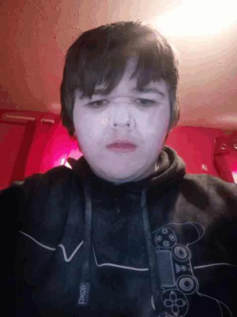 a boy wearing a black hoodie with the word xbox on the front