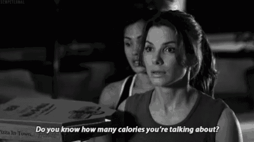 a woman is holding a box of pizza and asking how many calories she is talking about