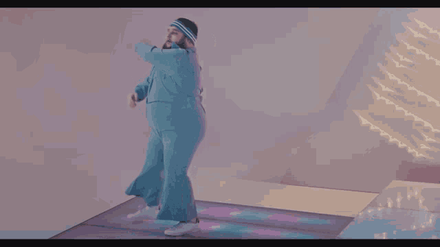a man with a beard is dancing on a dance floor in a room .