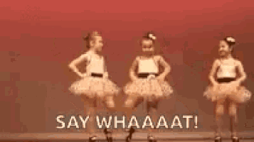 two little girls in tutus are dancing on a stage and saying `` say whaaat ! ''