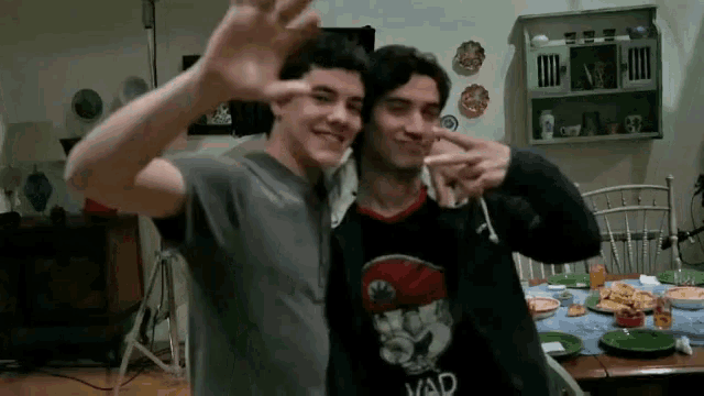 two young men are posing for a picture and one has a shirt that says yad on it